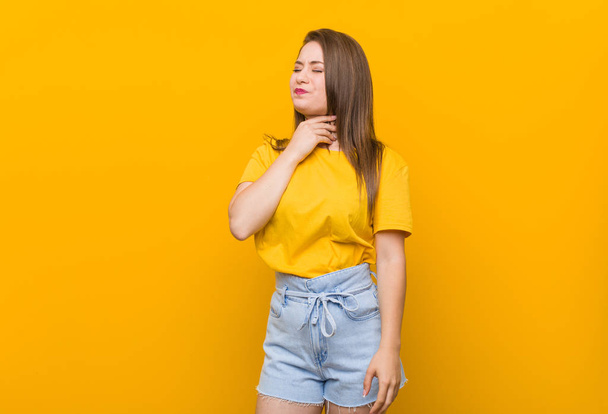 黄色のシャツを着た若い女性のティーンエイジャーは、ウイルスや感染症による喉の痛みに苦しむ. - 写真・画像