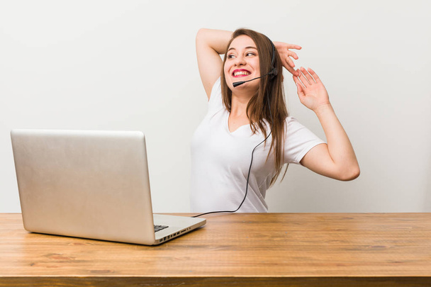 Young telemarketer woman stretching arms, relaxed position. - Photo, image