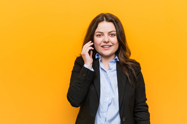 Fiatal kanyargós molett üzleti nő, kezében egy telefon boldog, mosolygós és vidám. - Fotó, kép