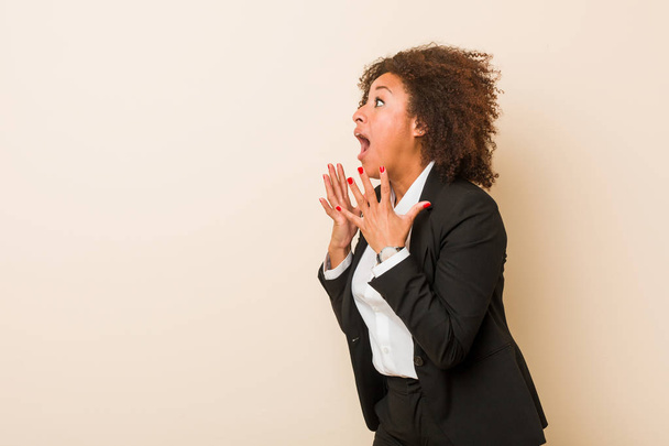 若いビジネスアフリカ系アメリカ人女性が大声で叫び、目を開け、手を緊張させ続ける. - 写真・画像