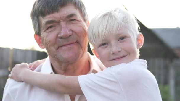 Boy hugs grandfather at sunset - Footage, Video