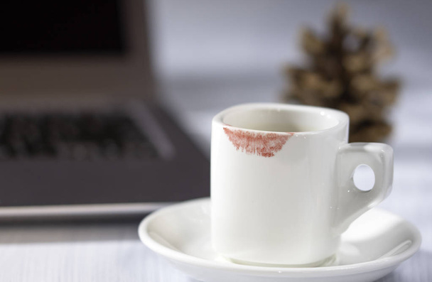 Marca de lápiz labial en la taza, taza blanca de café en la mesa, escritorio de mujer
 - Foto, Imagen