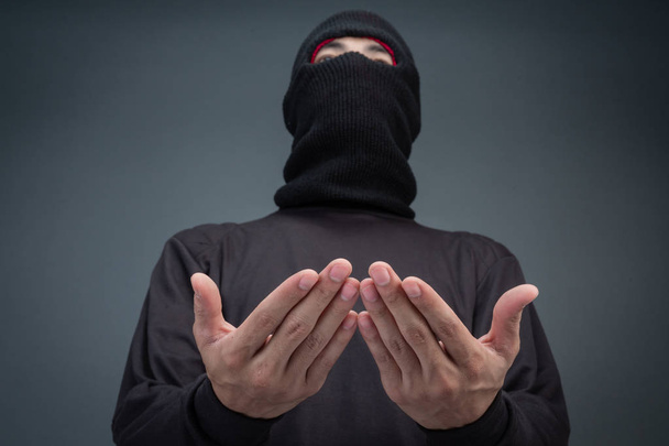 Criminals wear a mask in black on a gray background. - Фото, изображение