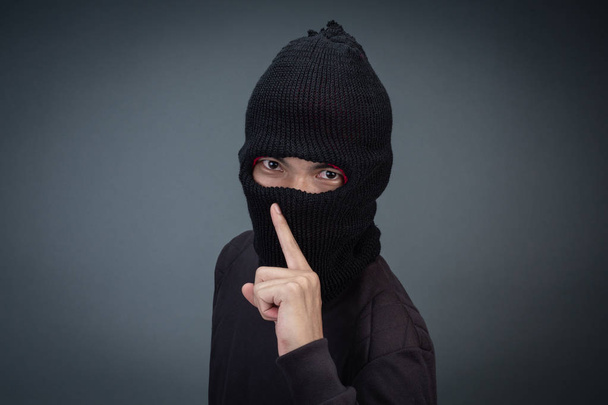 Criminals wear a mask in black on a gray background. - Foto, Imagen