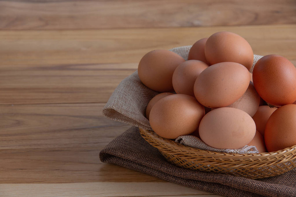 The eggs in the basket are placed on the wooden floor. - Foto, Imagem