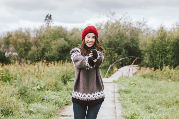 Piękne beztroski długie włosy Asian Girl w czerwonym kapeluszu i dzianiny Nordic sweter jesienią - Zdjęcie, obraz