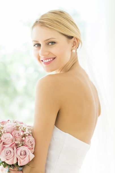 Bride In Backless Wedding Dress With Flower Bouquet Smiling - Фото, изображение