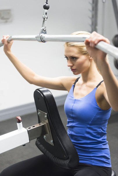 Woman Exercising On Pulley At Gym - Фото, зображення