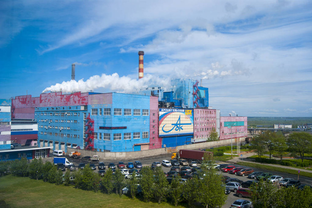 Letní Průmyslová krajina-Arkchangelská pulpa a papírenský mlýn, centrální hodinky, bílý kouř z trubek proti modrému nebi, redakční fotografie - Fotografie, Obrázek