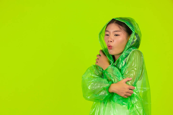 Girl is wearing a green rain dress on a green background. - Foto, Imagem