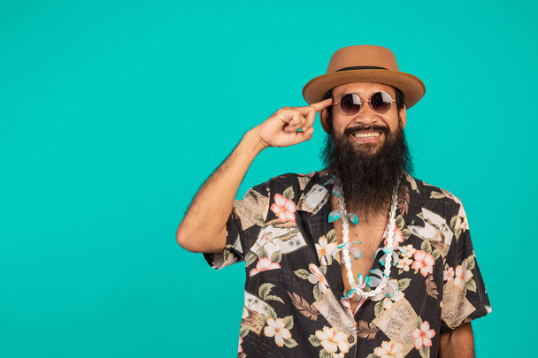 Concept of male tourists who have long beard wearing a hat on a blue background. - Foto, Imagem