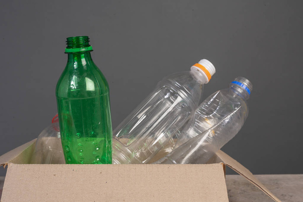 The plastic bottle in the box has a gray background. - Photo, Image