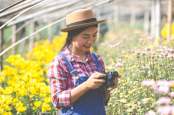 Agriculture girl is taking pictures of flowers. - 写真・画像