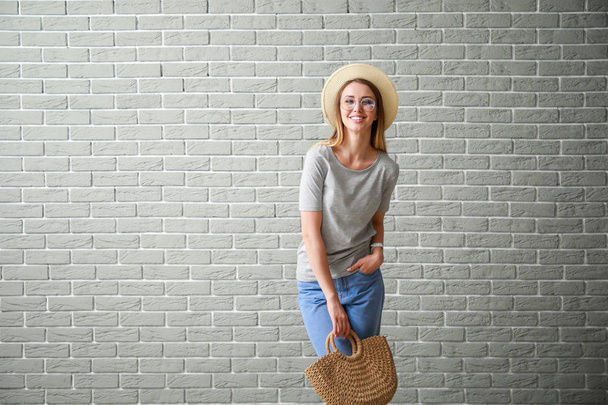 Woman in stylish t-shirt near brick wall - Photo, Image