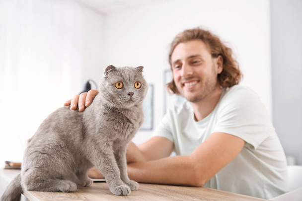Hombre con lindo gato divertido en casa
 - Foto, Imagen