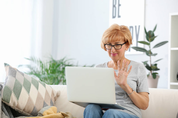Mulher de meia-idade bonita com laptop em casa
 - Foto, Imagem