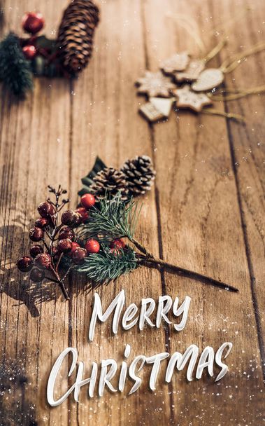 merry Christmas word with mistletoe leaf and pine cone on wood p - Fotoğraf, Görsel