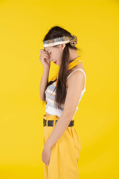 Fashion girl dress up with a hand gesture on a yellow background. - Foto, immagini