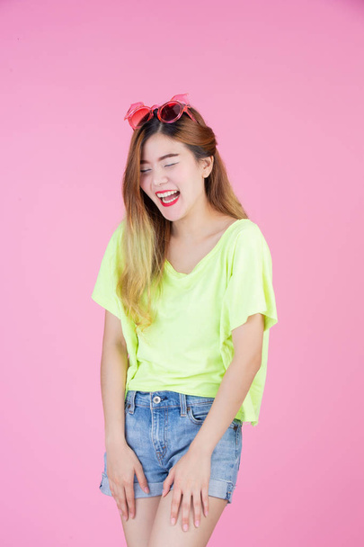 Fashion girl dress up with a hand gesture on a pink background. - Foto, Bild