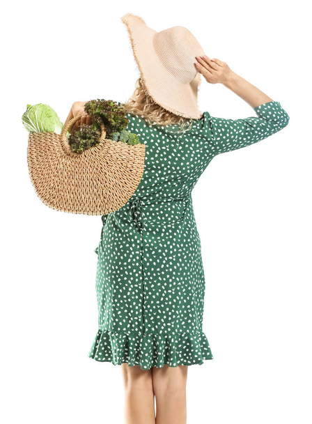 Vrouw met verse groenten in Eco-tas op witte achtergrond, achteraanzicht - Foto, afbeelding