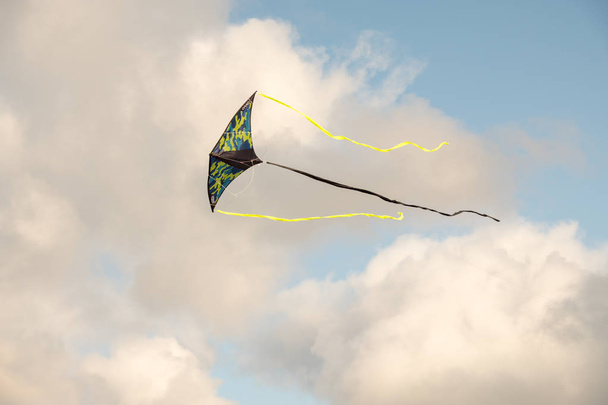 Sárkányeregetés a kék ég ellen. A játék, hogy repül a levegőben való kitettség szél. Kábelek által irányított. Nyári. Nap. - Fotó, kép