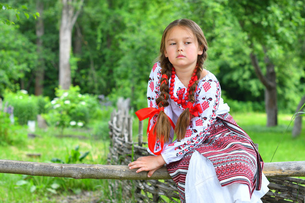Portret van Oekraïens mooi meisje in vyshivanka naast het oude houten huis. meisje in borduurwerk. Concept van nationale tradities - Foto, afbeelding