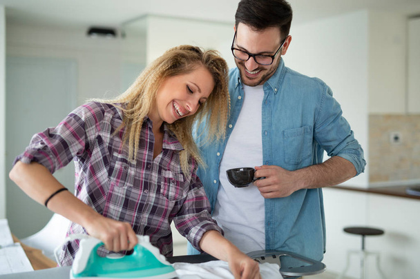 Young couple doing the ironing together at home - Φωτογραφία, εικόνα