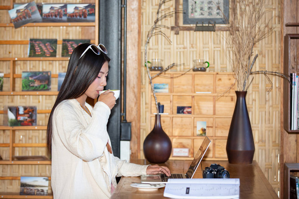 Female tourists are drinking coffee in the morning in the coffee shop. - 写真・画像
