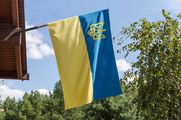 空に対する建物のファサード上のウクライナの国旗 - 写真・画像