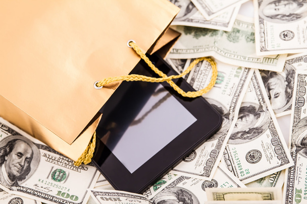 Gold gift bag with a Tablet and dollars - Photo, Image