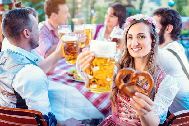 Женщина тост за камеру со стаканом пива в баварском пабе - Фото, изображение