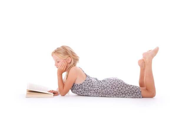 young girl reads a book lying down - 写真・画像