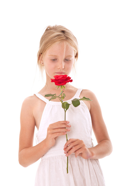 young girl in white dress smelling a rose - Foto, afbeelding