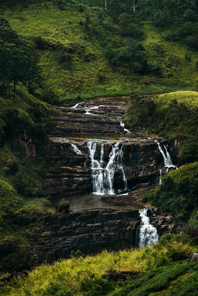 Waterfall among the green mountains. Waterfalls Of Sri Lanka. Landscapes Of Asia. Aerial photography. Tea plantation. Green hill. Mountain river. Small waterfall. Sri lanka - Фото, зображення