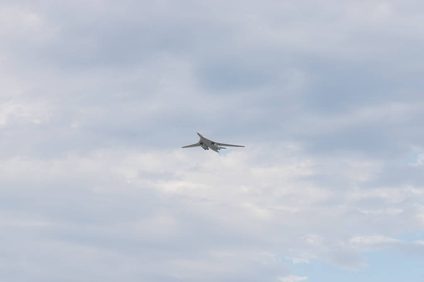 Military bomber aircraft flying in the cloudy sky in daylight - Photo, Image
