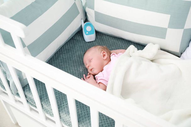 Lindo bebé con niñera de radio durmiendo en la cuna
 - Foto, Imagen