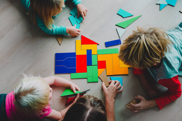 leraar en kinderen spelen met puzzel, doen tangram - Foto, afbeelding
