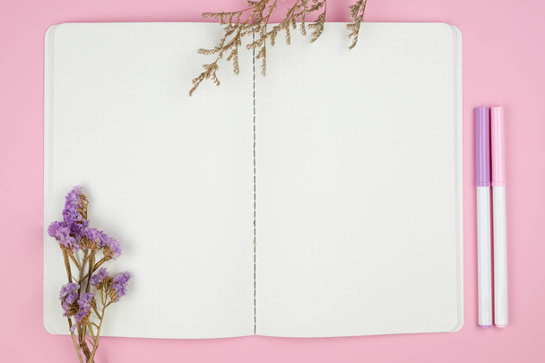 Вид сверху ноутбука канцелярские принадлежности и цветок на розовом фоне
 - Фото, изображение