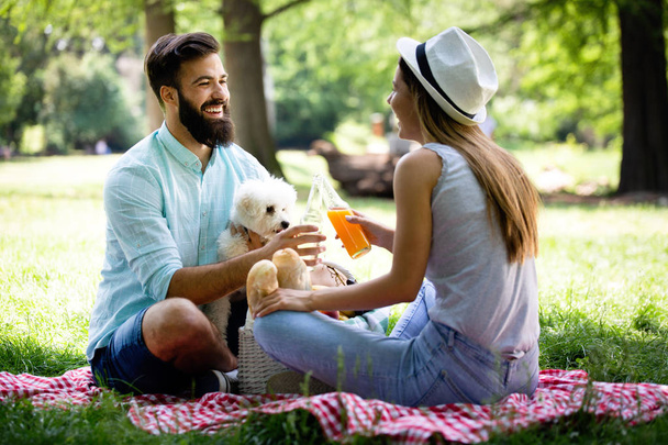Lifestyle, happy family resting at a picnic in the park with a dog - Foto, Bild