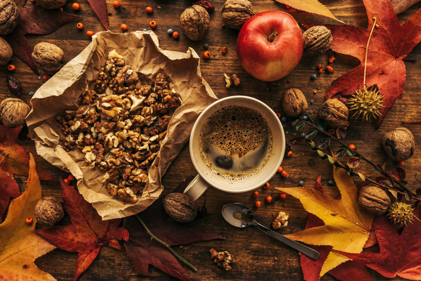 Enjoying fruits of autumn - apple, coffee and walnut on table - Foto, afbeelding