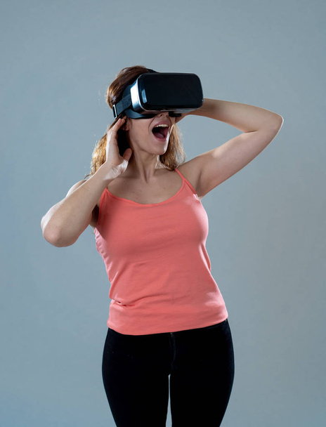 Amazed woman getting experience using VR headset glasses, feeling excited about simulation, exploring virtual reality making gestures interacting with new virtual world. In new technology concept. - Photo, image