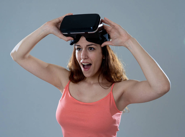 Virtual reality experience. Young caucasian happy woman about to use VR goggles feeling excited about simulation and exploring virtual life. In New technology Virtual Augmented Reality concept. - Zdjęcie, obraz