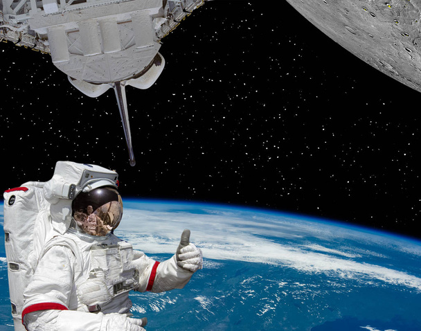 Astronot thumbs-up verir, dünya ve gezegen mo gibi kraterler ile - Fotoğraf, Görsel