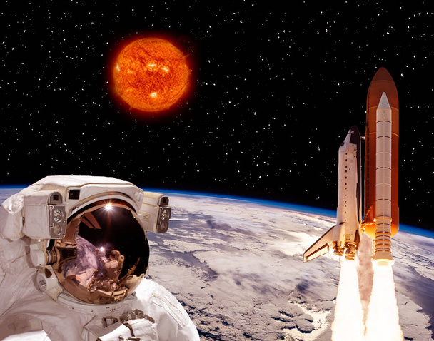 Astronauta a olhar para o foguetão que voa da Terra. Grande sol
  - Foto, Imagem