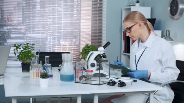 Scientifique en chimie intelligente en blouse de laboratoire écrivant les résultats de l'expérience
 - Séquence, vidéo