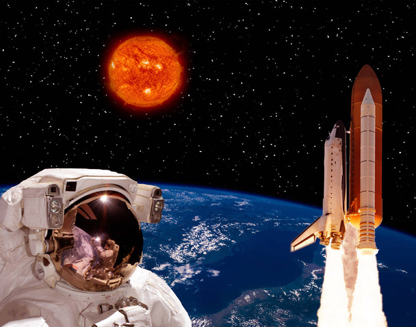 Astronautti tuijottaa maasta lentävää rakettia. Iso aurinko
  - Valokuva, kuva