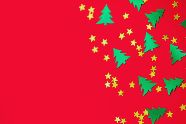 зеленые рождественские деревья и золотые звезды конфетти редки на красной спине
 - Фото, изображение