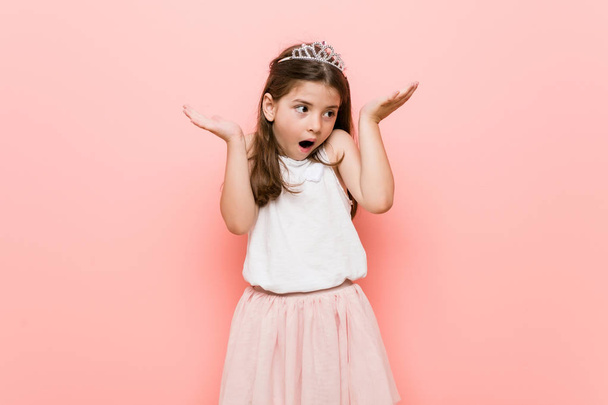 Little girl wearing a princess look surprised and shocked. - Photo, Image
