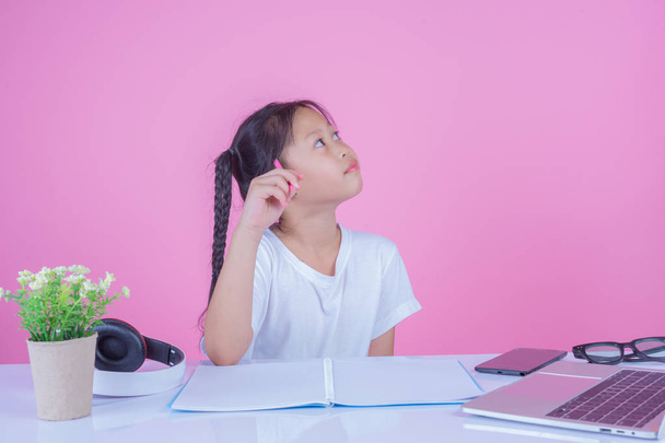 Mädchen schreiben Bücher auf rosa Hintergrund. - Foto, Bild