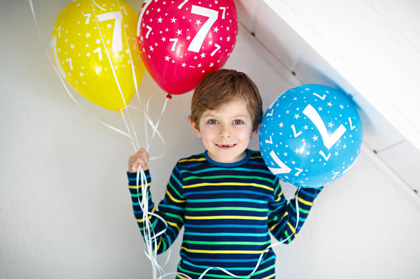 7 歳の誕生日にカラフルな気球の束を持つ幸せな子供少年の肖像画 - 写真・画像